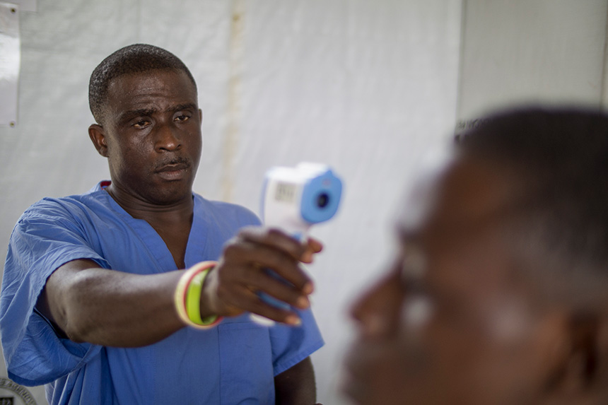 Taking a visitor's temperature at a health clinic in Liberia