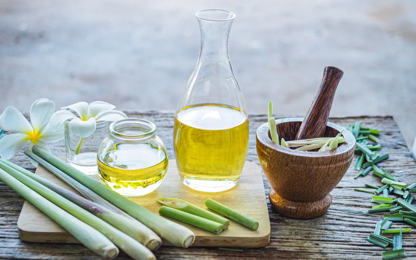 Lemongrass plant and oil next to a mortar and pestle 