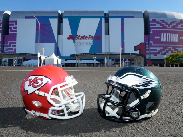 Two helmets, one Kansas City Chiefs and one Philadelphia Eagles, resting in the parking lot of State Farm Stadium in Arizona set for Super Bowl LVII in 2023.