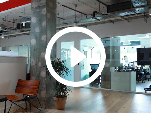 Industrial style workspace with exposed ceiling above floor to ceiling interior windows and wooden floor design Skype background