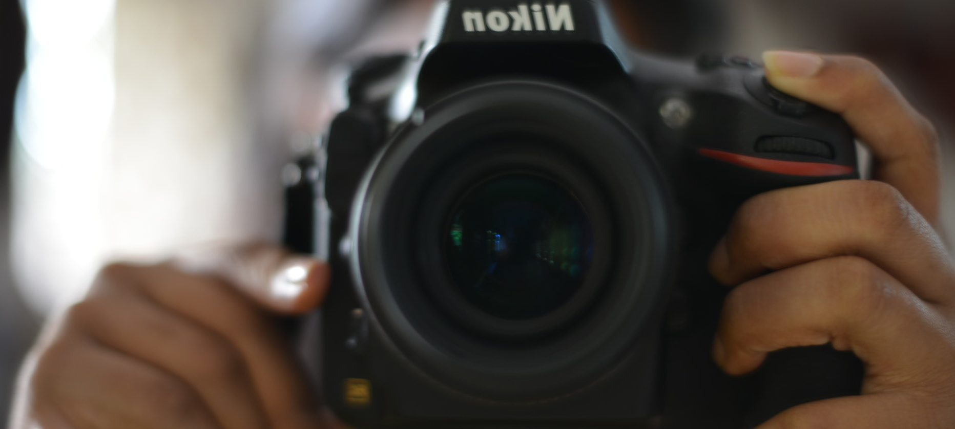 A nikon camera in center frame pointing at the camera