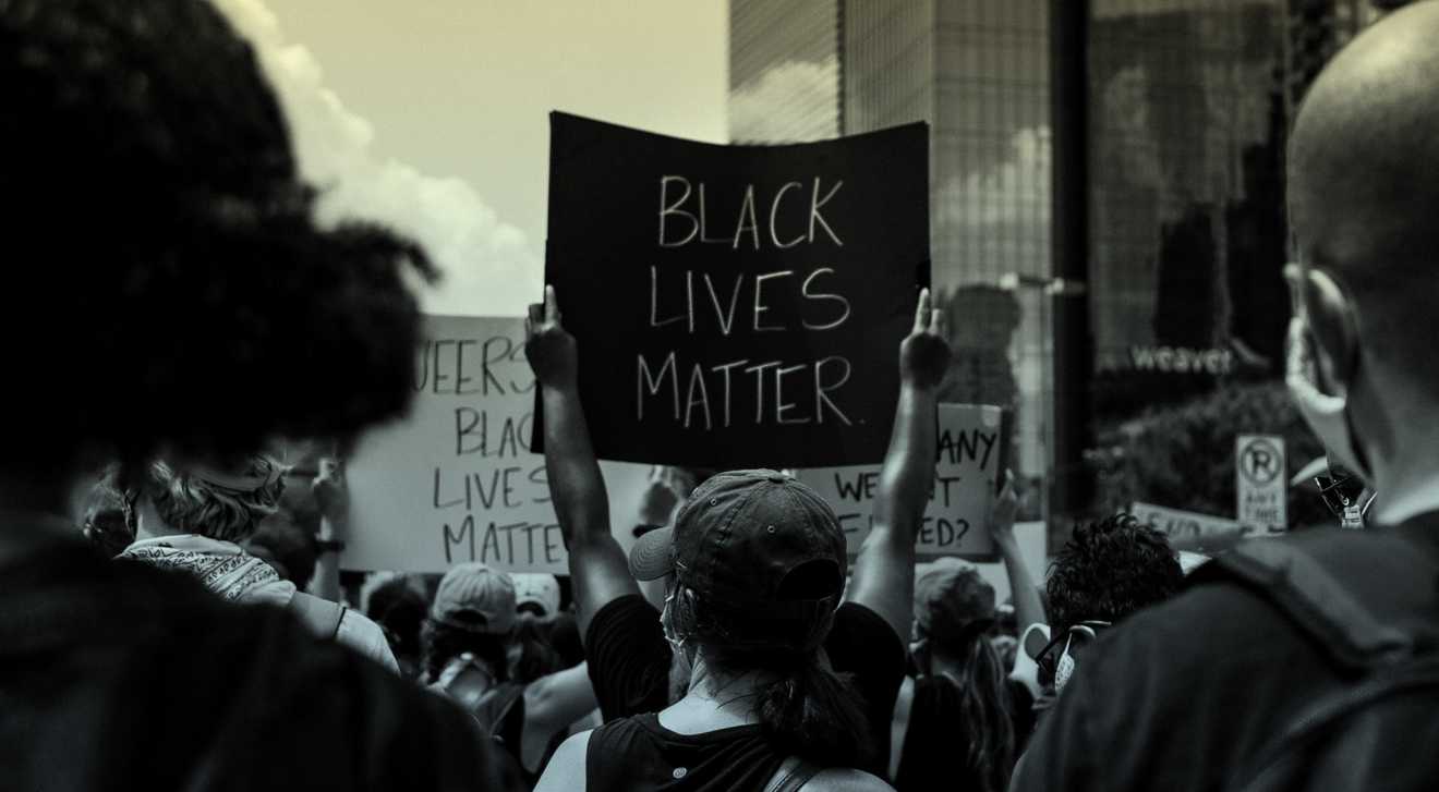A group of people holds anti-racism signs at a Black Lives Matter protest