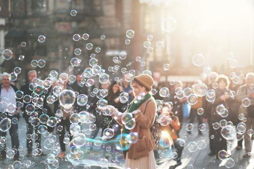 Woman standing in many bubbles on a nice day outside.