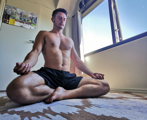 Man sitting cross legged meditating with pectus excavatum