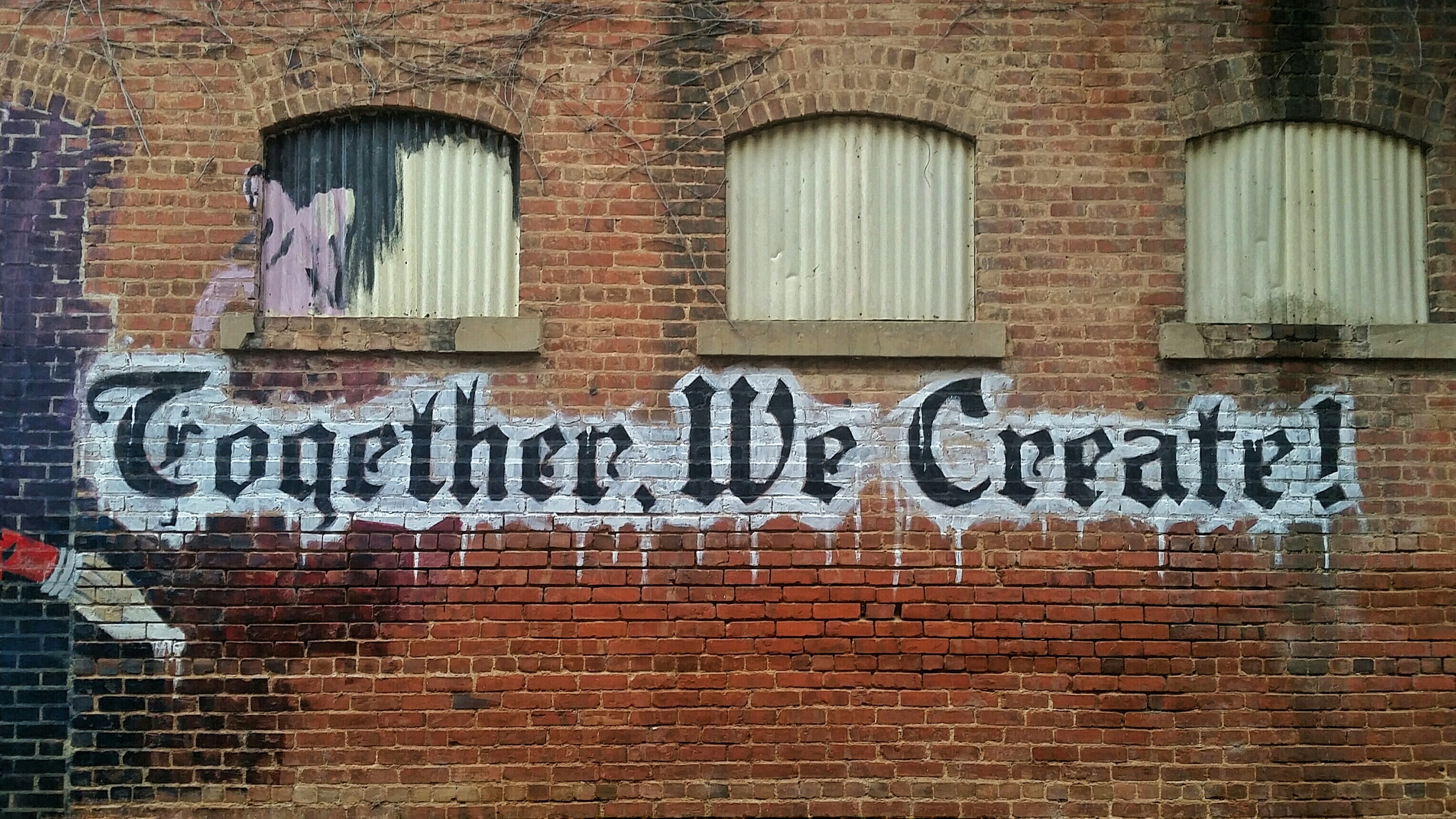 A graffiti in Blackletter typeface with the words 'Together, We Create!'
