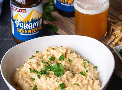 Bowl of Hearty Hefeweizen And Gouda Risotto with a bottle and glass of Pyramid Hefeweizen