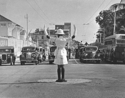 A traffic policeman guiding vehicles at a junction, 1950s