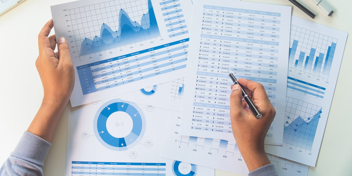 What is quantitative data? A bird's-eye view of a pair of hands holding printouts of graphs and charts