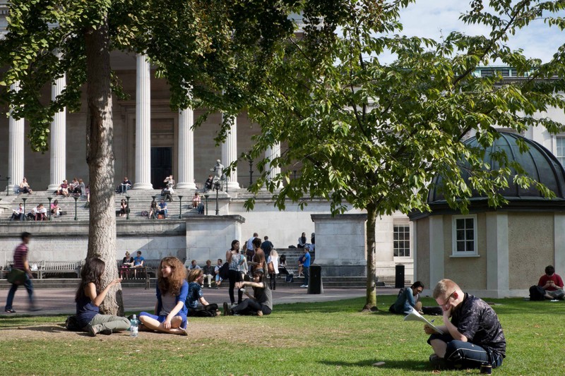 Students socializing and reading on the steps and quad at UCL's Main Building