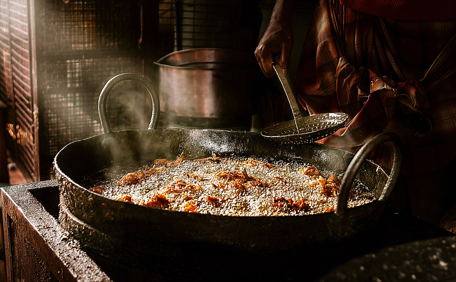 a man frying onion fritters