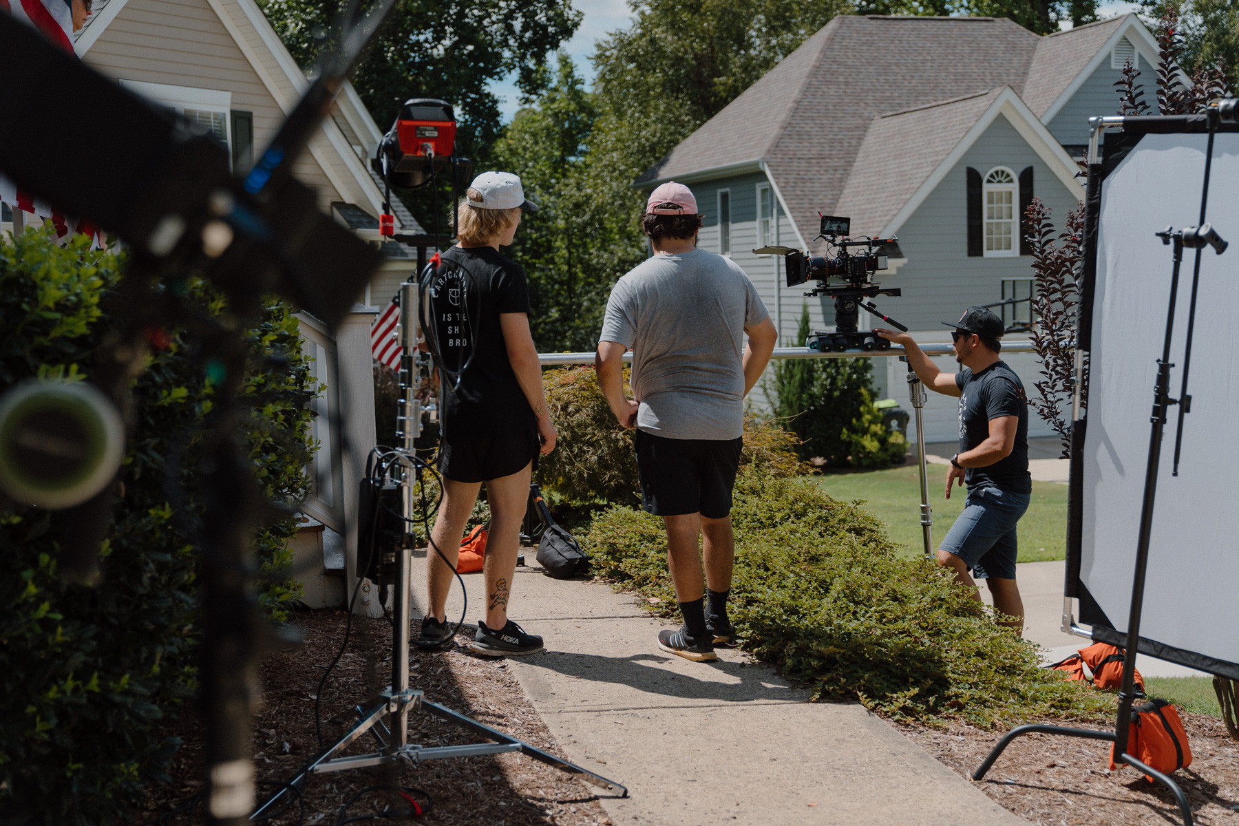 Film crew standing around the side of a house