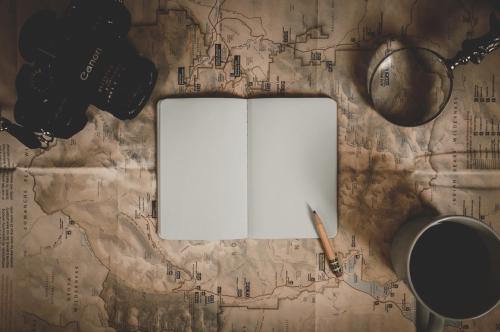 Thumbnail a journal, a pencil, and a coffee on top of a map