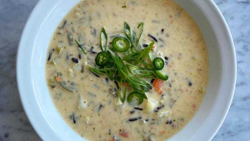 photo of completed recipe: Spicy and creamy, this vegetarian soup is kind of like a warm hug. The wild rice (which isn’t actually rice! but a rice-looking seed harvested from a type…