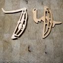Die cut balsa pieces from a model mantis on a chopping board. Together they spell the digits of seventy four.