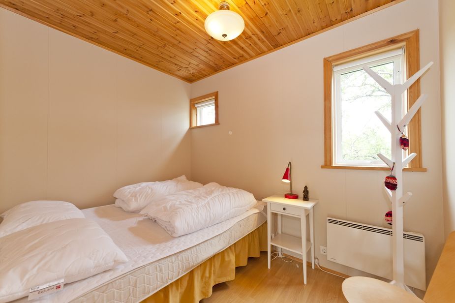 Das linke Schlafzimmer hat ein Doppelbett und zwei Fenster zum Wald