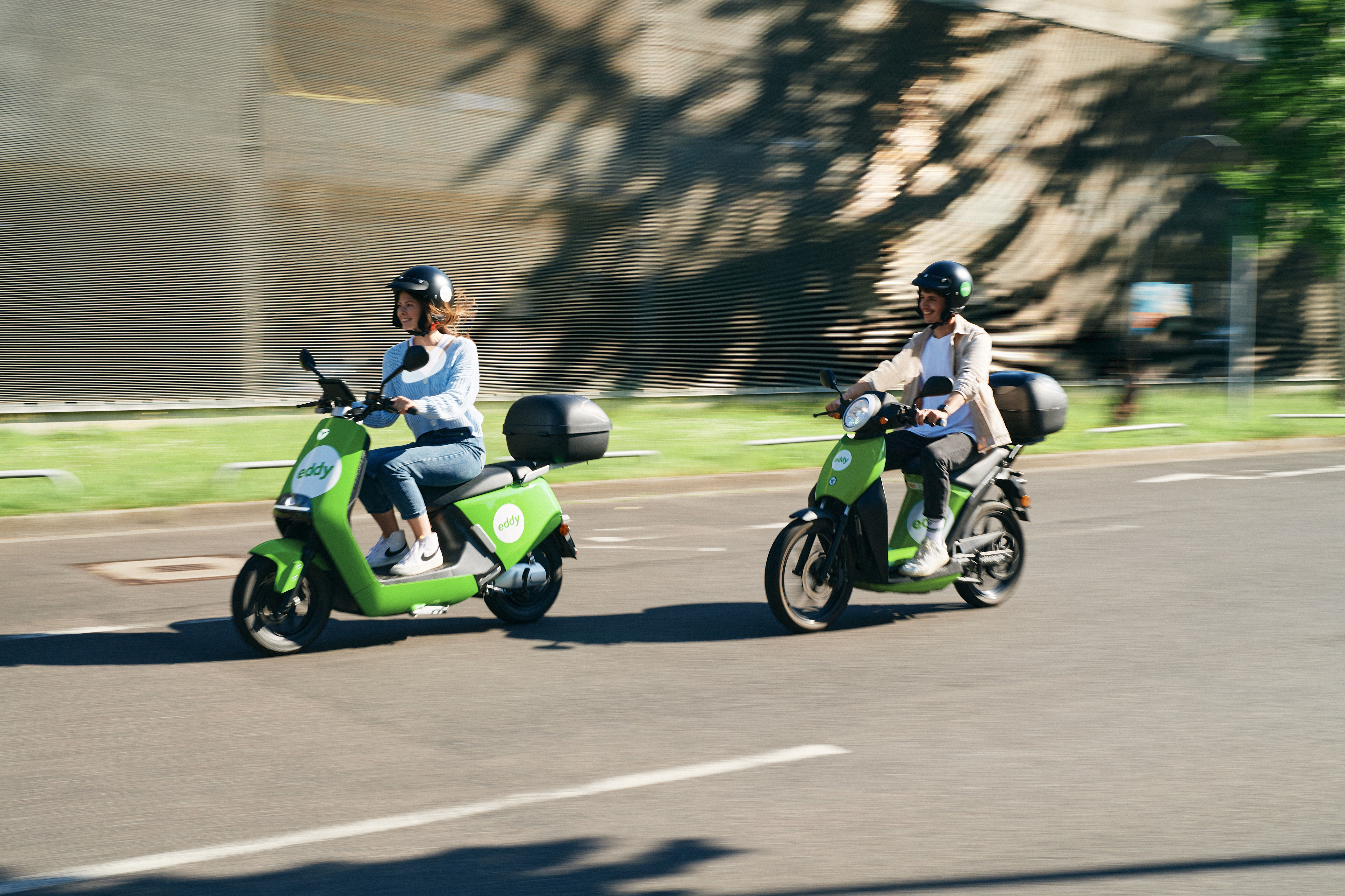 Eddy card image with causcasian people smiling together and riding electric moped.
