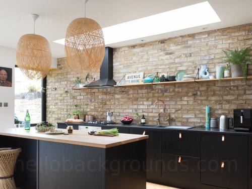 Airy modern kitchen with bare brick walls featuring black wooden fittings and kitchen island with wooden top Zoom background