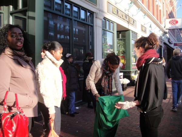 In Central Square, Cambridge, two women look on as a third tries on a green lycra body sock. I'm there, speaking with them about the project.