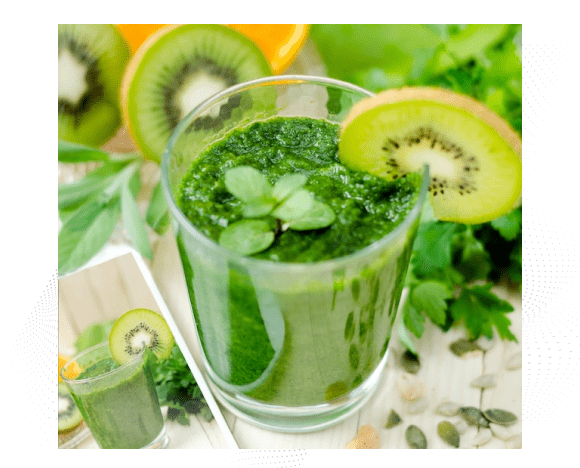 Green healthy drink in a clear glass with a kiwi slice on right top of glass to accentuate the drink. Behind the glass are different green vegetables and kiwi slices with an orange bowl in top left corner. The bottom left is a cascading image of the same glass from a different angle.