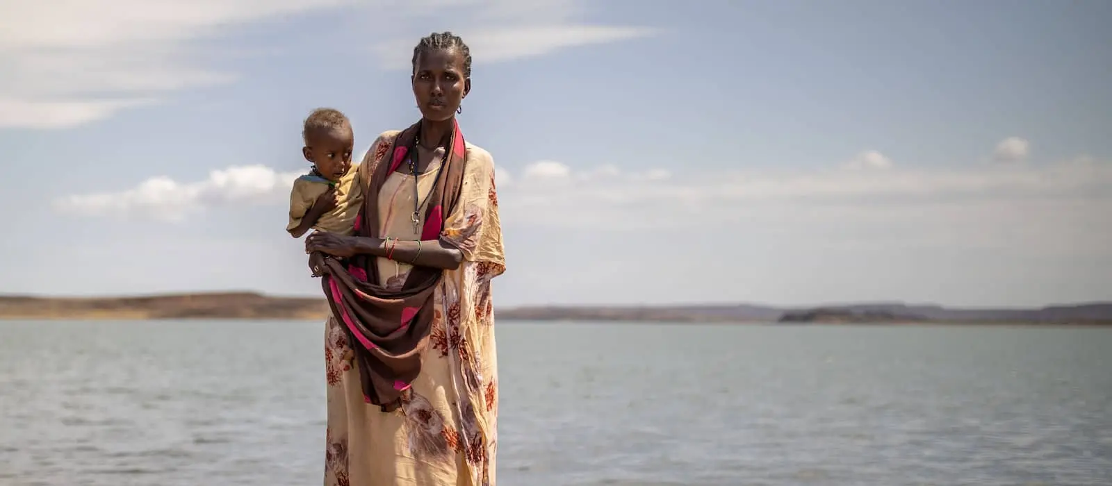 A Kenyan woman in Lake Turkana, an area hit hard by climate change, holds her baby