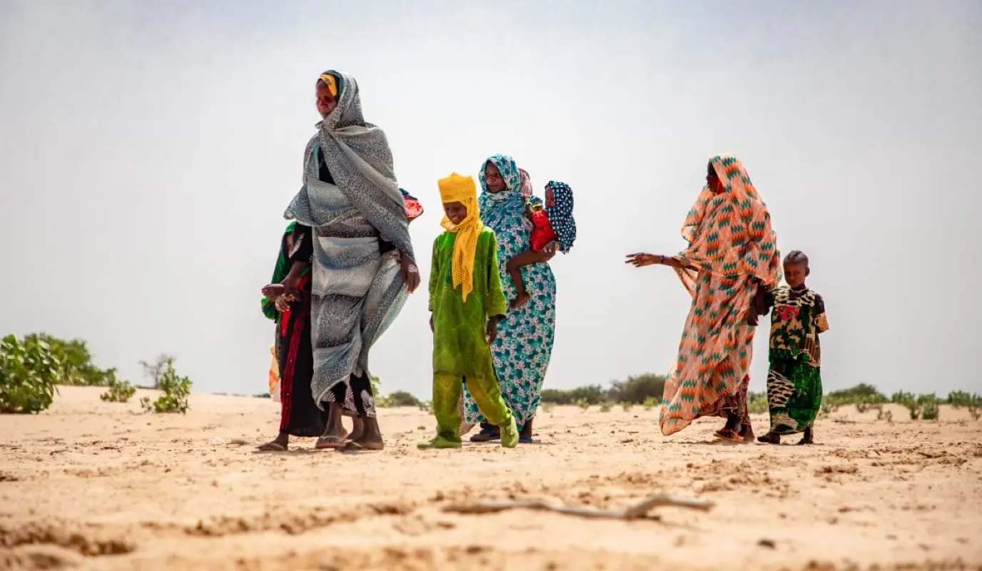 Women and children in the barren landscape of the Lake Chad region.