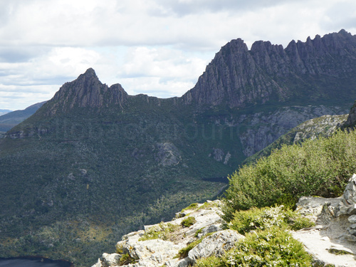 Mountain range with green shrubs in foreground Zoom background