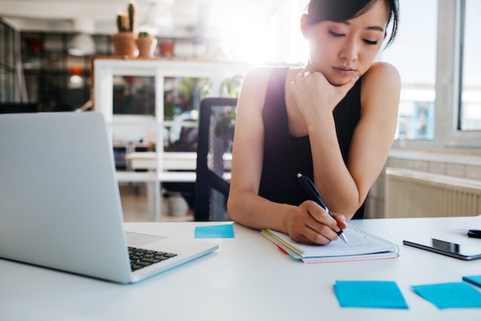 A woman writing something in a notebook