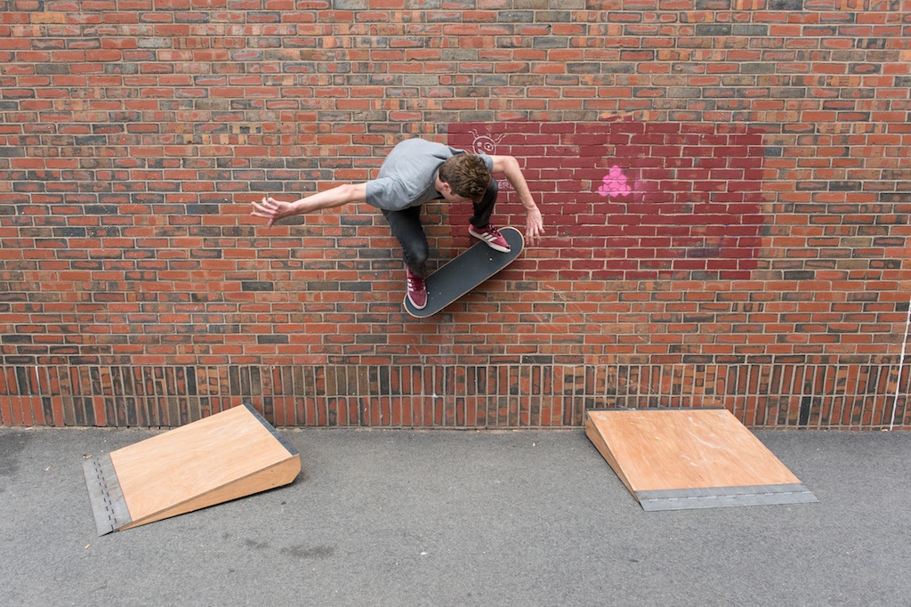 A skateboarder uses two of my ramp designs to skate across a wall in Boston.