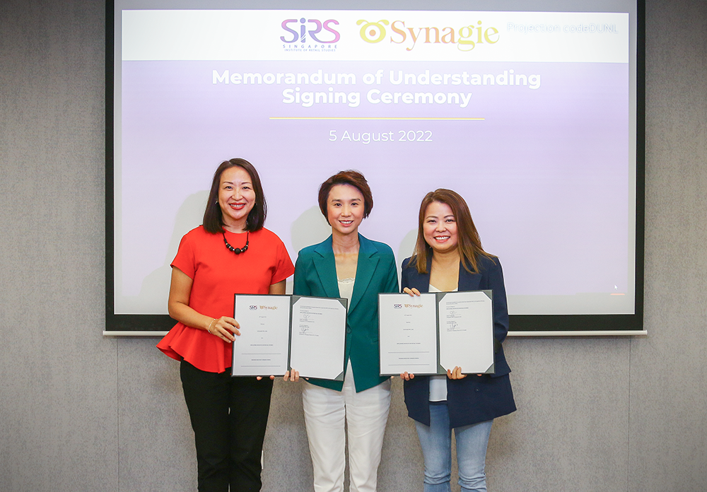 MOU signed by Jeanne Liew PCEO NYP and Olive Tai MD Synagie, witnessed by MOS Low Yen Ling