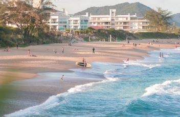 Vista da praia da praia do Morro das Pedras com mar azulado e banhistas na areia