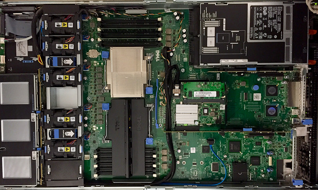 Top-down photo of an open Dell R610 server chassis, showing off a
proprietary form factor L-shaped motherboard with nonstandard addon
cards.
