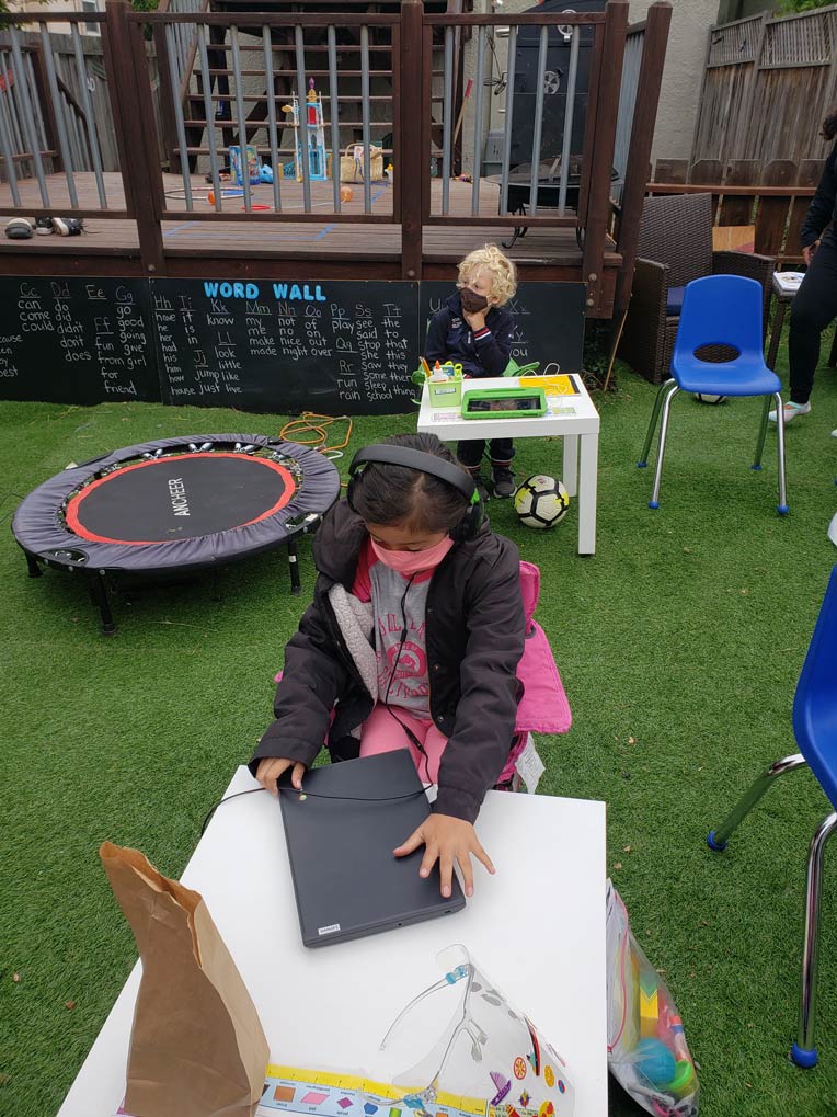 Two students wearing masks in the outdoor learning pod space