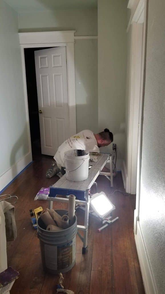 enlarged photo of man painting the interior wall of a home