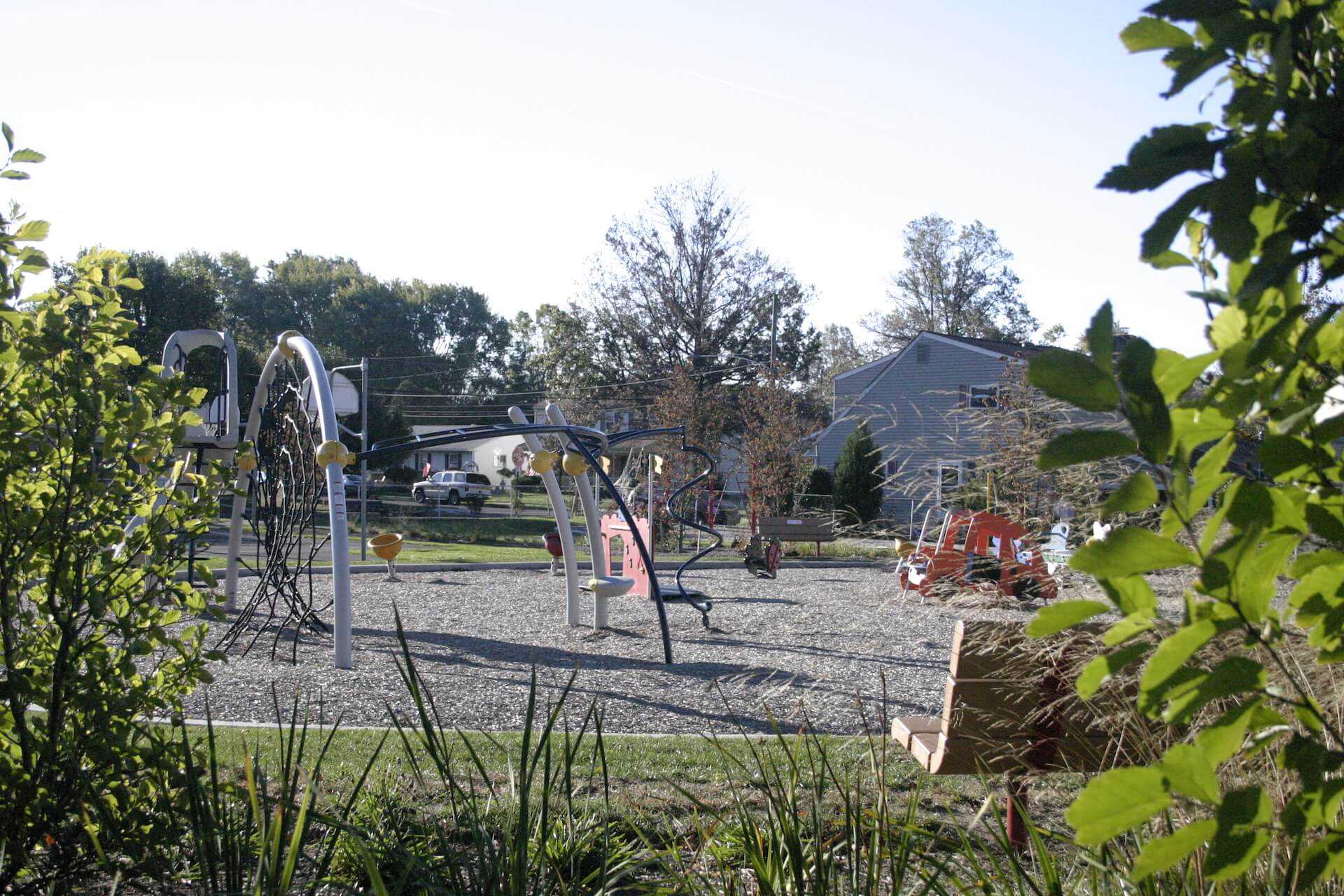 playground behind landscaping and park bench