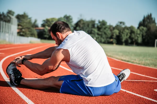 Man stretching on a running track