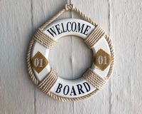 Un salvavidas que dice 'Welcome board' colgado en la pared.