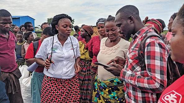 Ugandan barley farmers learn how to use the BanQu blockchain app on mobile phones.
