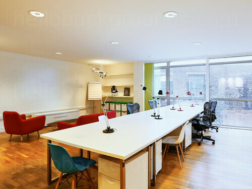 Spacious shared workspace featuring red padded furniture next to wooden table with reading lamps and office chairs Zoom background