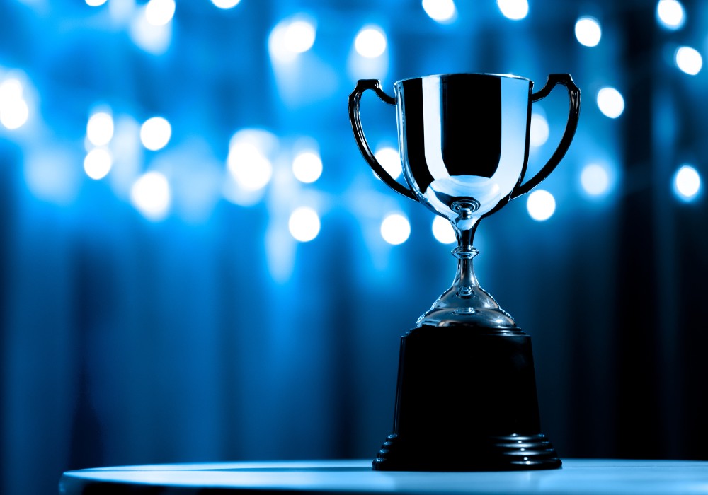 blue background with lights shining on a trophy