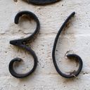 House number thirty six in black painted curved metal digits on a white painted wall.