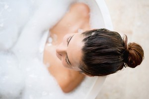 Beautiful woman taking a bath and relaxing at home - lifestyle - feminine hygiene products