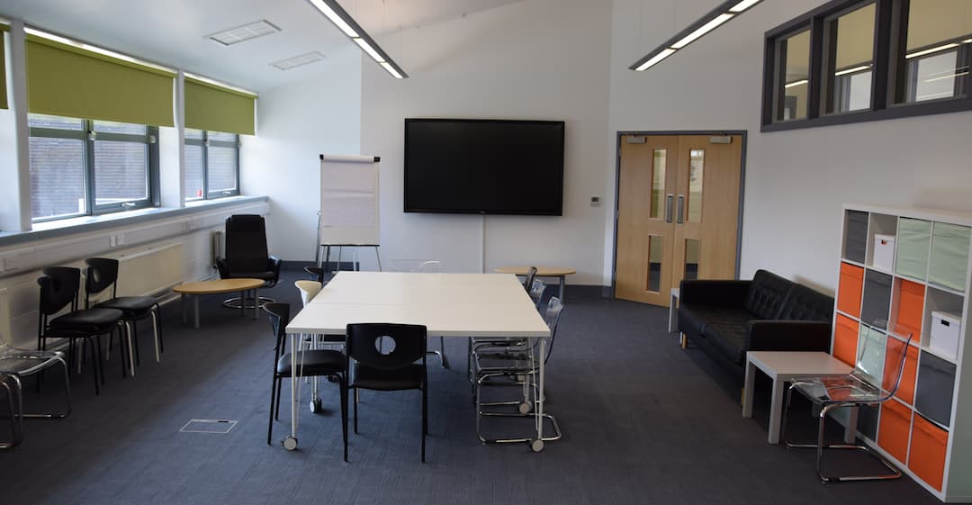 Room with large screen and seats and chairs
