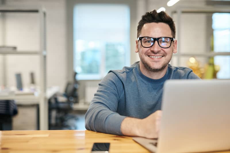 Mann mit Brille sitzt am Laptop