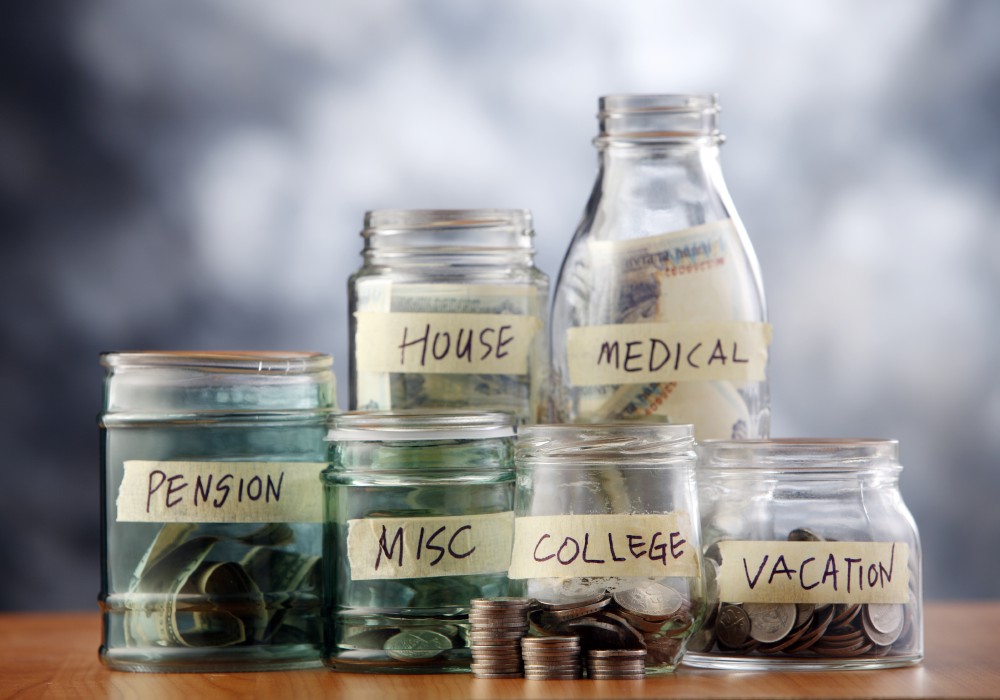 Jars of money with different labels like medical, vacation, etc.