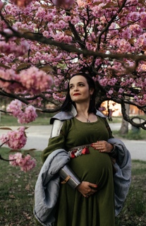 Sesja ciążowa Poznań - stylizowane zdjęcia - kobieta w zbroi pod kwiatami