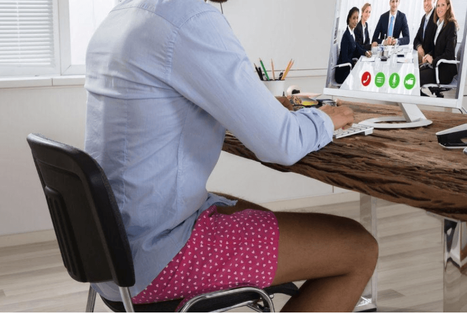 Man working remotely at computer with dress shirt and no pants