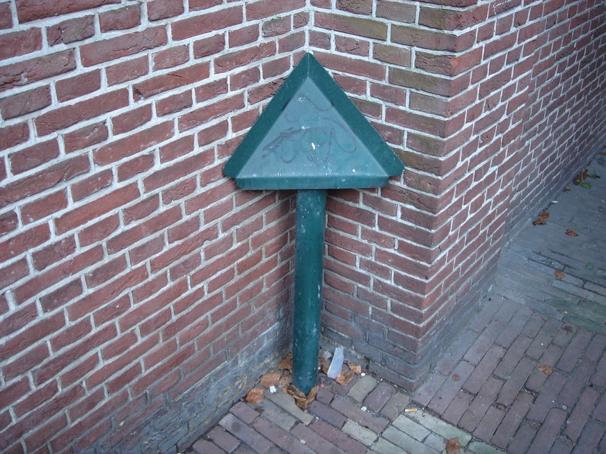 Utrecht anti-urination image: a small metal pipe and a flat inclined metal surface fits precisely into a corner, making it a splashy, messy choice to eliminate