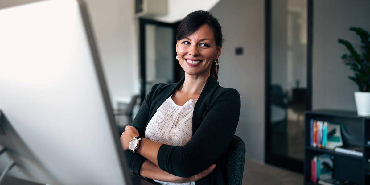 Affordances, Signifiers, and Feedback Designer sitting at her desk, smiling.