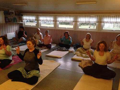 flere mennesker i et rom som gjør yoga