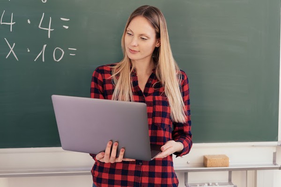 Math teacher with a laptop uses data-driven decision making.